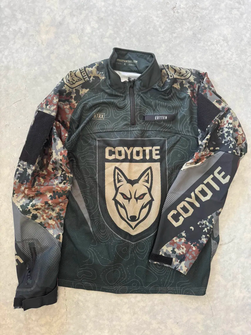 Camouflage jersey with 'Coyote' branding on a textured surface